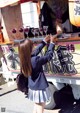 A woman in a school uniform standing in front of a food truck.